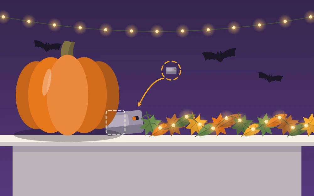A battery pack hidden behind a pumpkin, its wire of tiny lights winding through a garland
