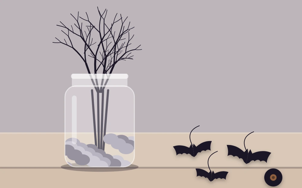 Bare branches arranged in a jar weighted with pebbles, with paper bats on threads ready to hang