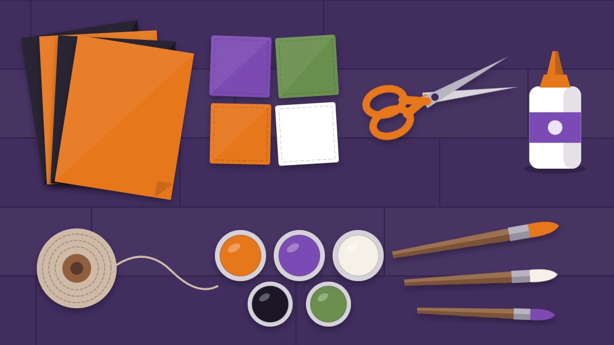 Flat lay of craft supplies on a dark table: black and orange paper, felt squares, scissors, glue, twine, paint pots and brushes