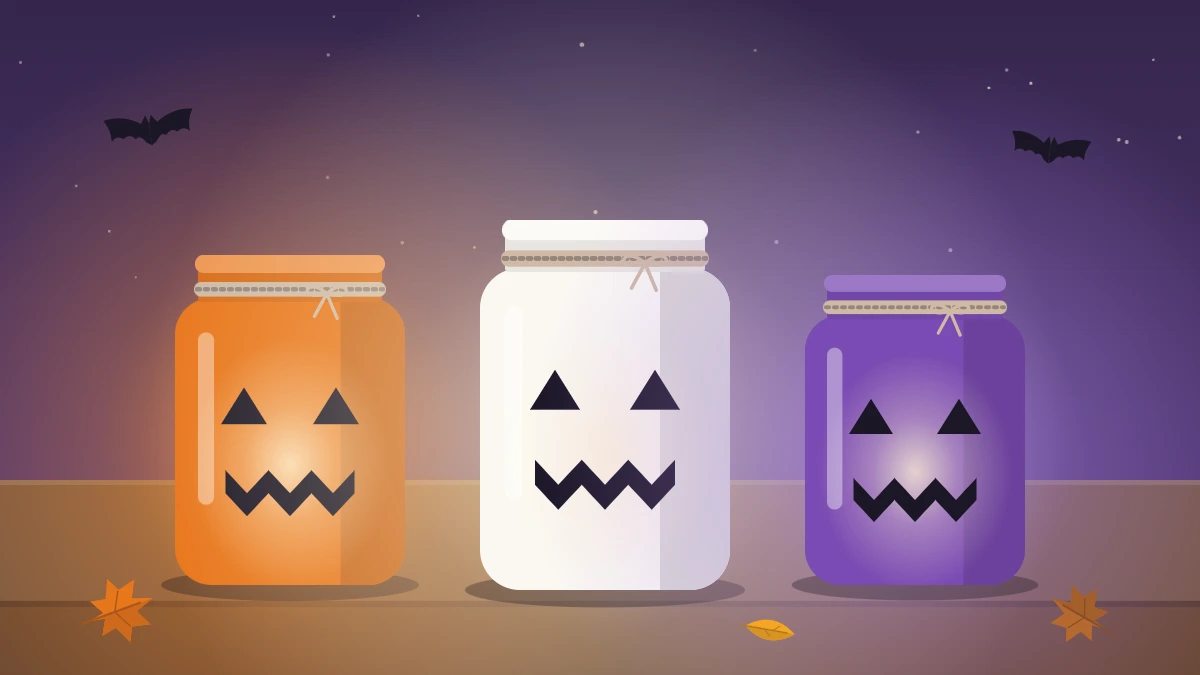 Three glowing glass jar lanterns in orange, white and purple with black paper faces and twine tied at the rims