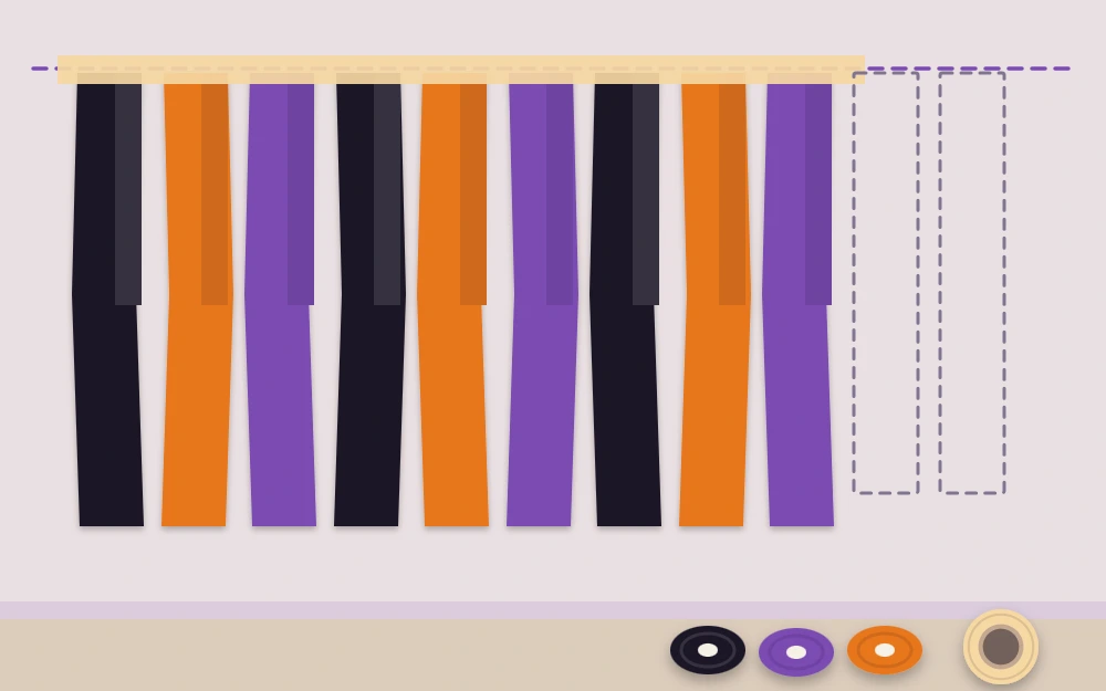 Streamer strips taped along the top of a wall, alternating black, orange and purple