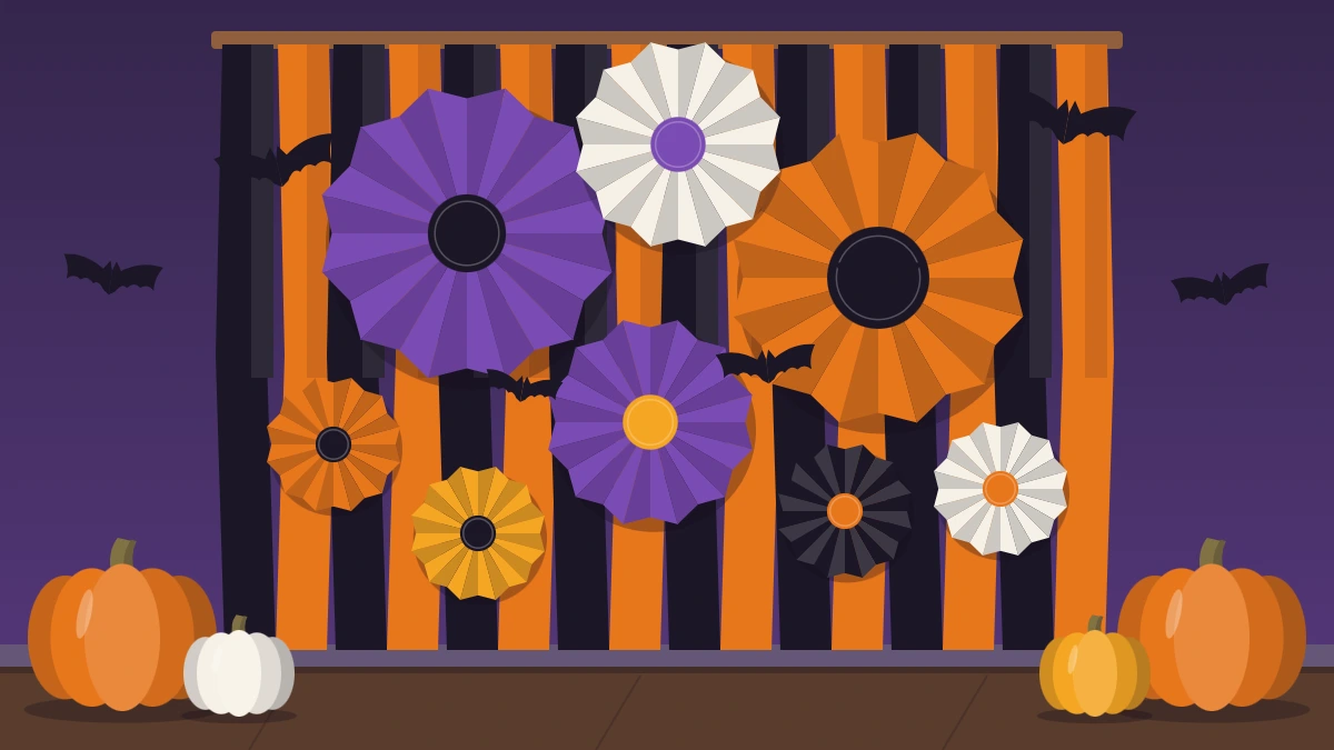 A photo backdrop wall with black and orange streamers, paper fans, paper bats and pumpkins on the floor